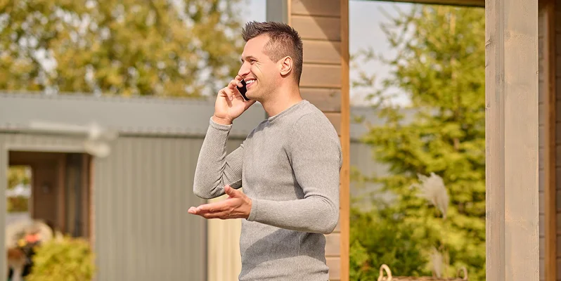 Man talking on the phone outside his home