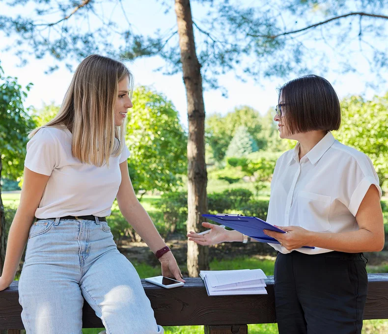 Tree care professional consulting with a woman outdoors