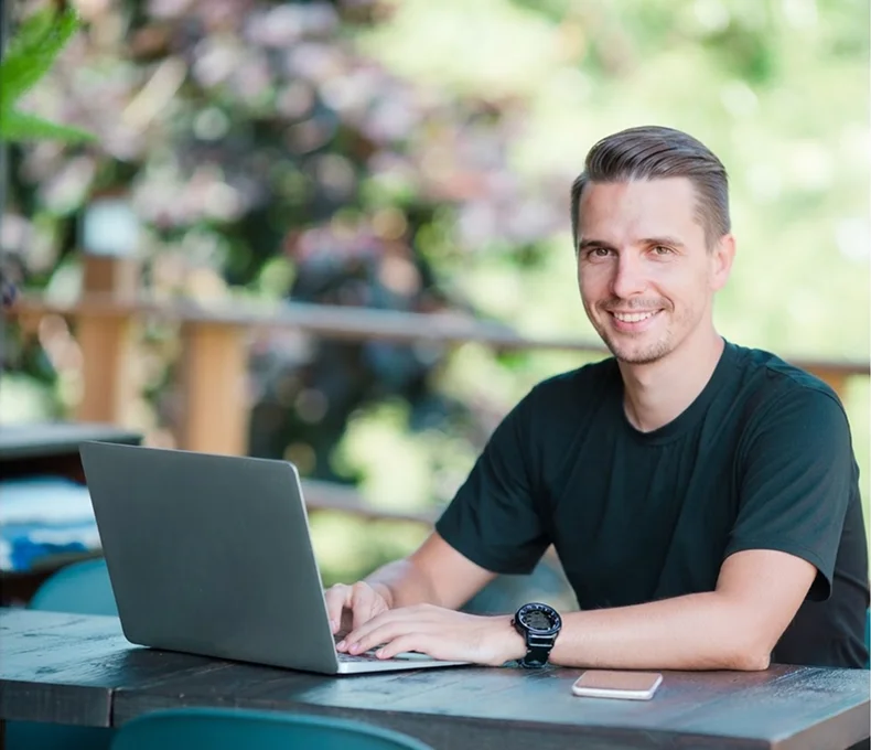 Tree care professional working on a laptop outdoors