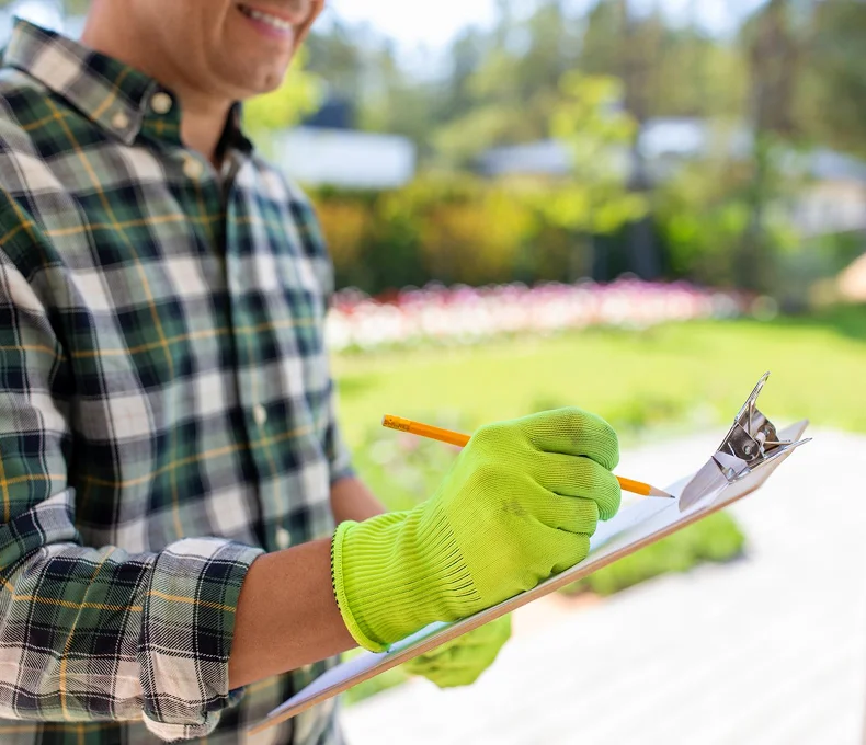 Tree care professional taking notes during a property inspection